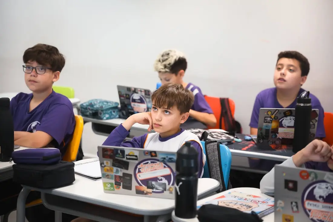 Alunos do Fundamental II da Evolution Teens com seus notebooks em sala