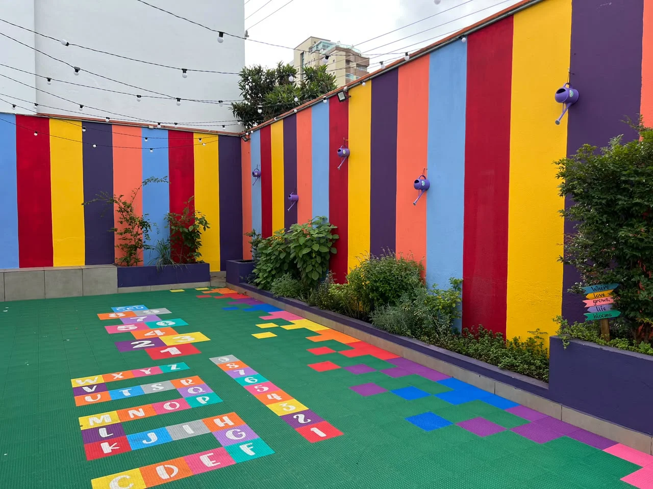 Garden da Evolution, com plantas, paredes coloridas e jogos no piso
